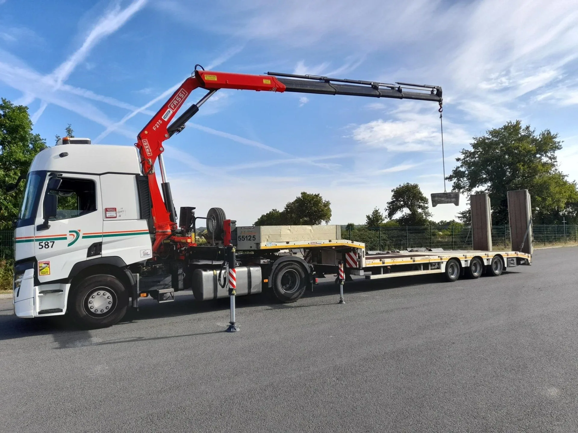 Camion plateau-grue transportant une charge volumineuse